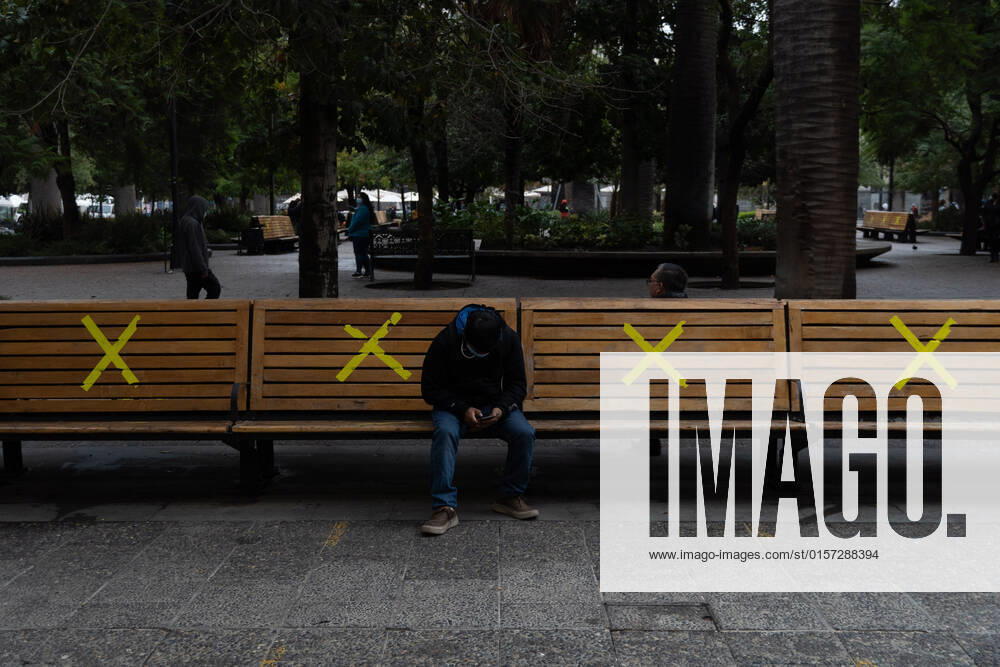 A man sits on some benches, marked with X at the start of the pandemic, in downtown Santiago, Chile. Santiago Chile - ZUMAb332 20220427_zip_b332_003
