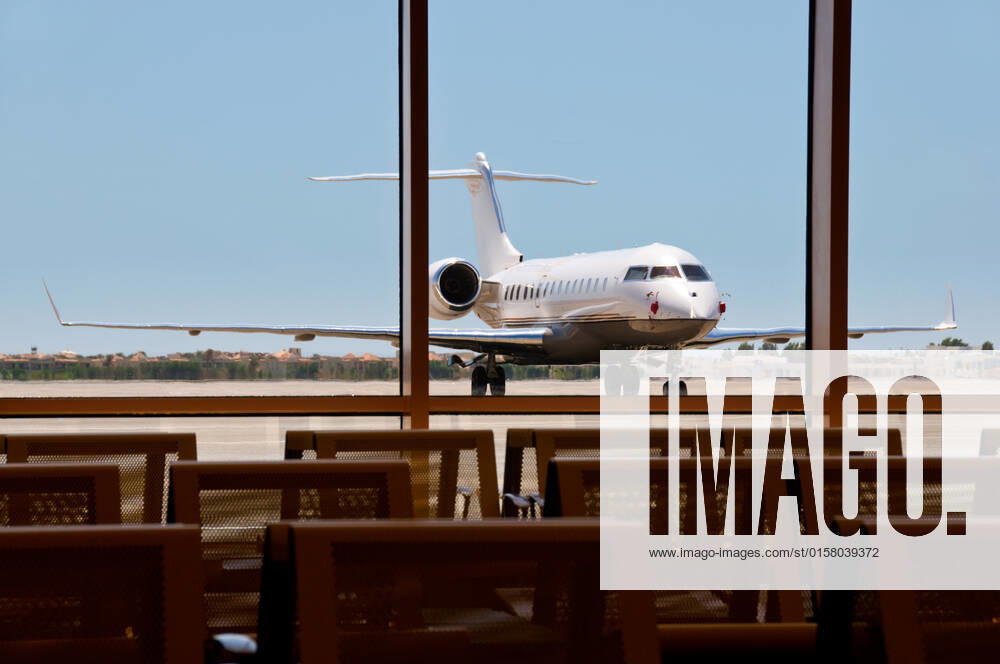 Business plane parked in an airport with seats on foreground. Focus on the plane. , 3044277.jpg, seat, metal, plane, angled, mode, travel, business, jet, private, vehicle, transport, airplane, blue, airport, air, white, corporate, contemporary, asphalt, commercial, luxury, class, stationary, transportation, sky, upper, space, nobody, horizontal, star, wealth, charter, parked, business, technology, challenger, object, front, sparse, single, road, chassis, wing,