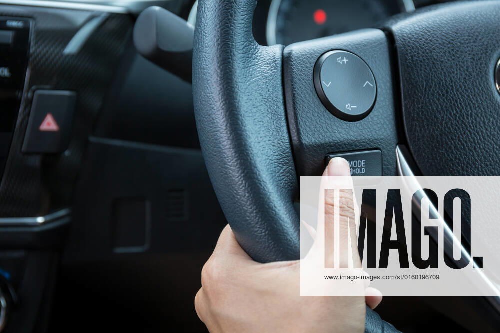 A woman hand pushes the mode hold control button on a steering wheel. , 20311954.jpg, wheel, hand, control, auto, cruise, mode, thumb, dashboard, steering, toggle, black, vehicle, technology, close-up, automobile, modern, transport, system, panel, decrease, decelerate, interior, drive, accelerate, speed, inside, electronic, transportation, set, increase, car, leather, detail, switch, button, multi, function, mode, hold, woman, power, luxury, driver, display, safe,