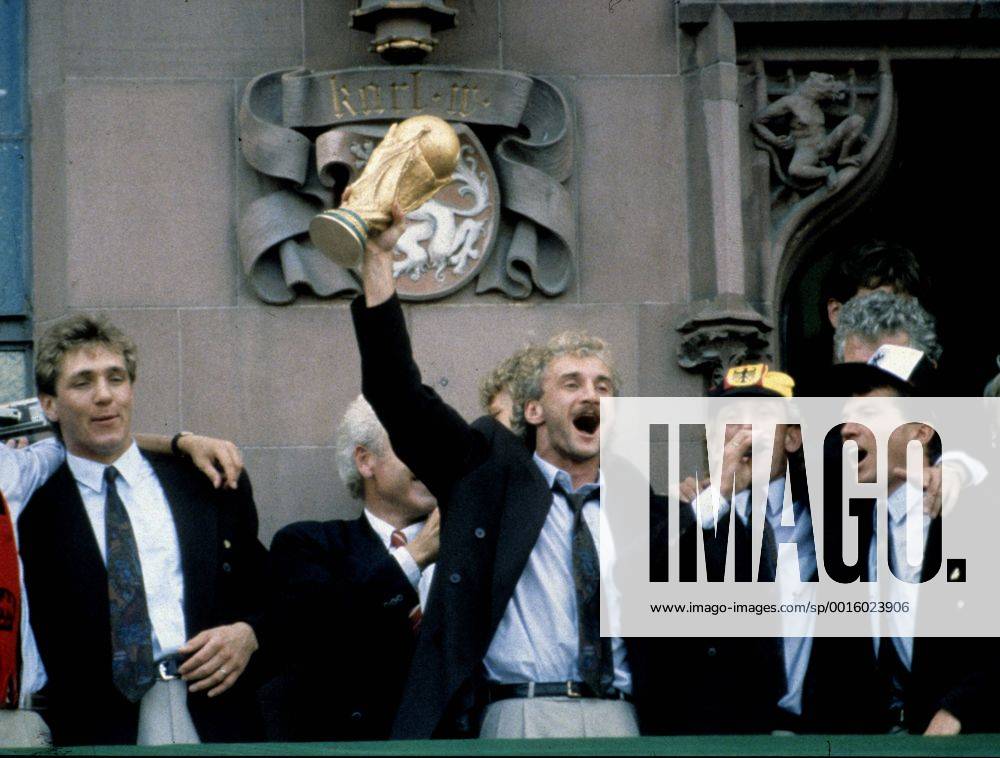 1990 - Weltmeister Deutschland feiert: Rudi Völler mit dem Fussball Weltpokal, daneben Torwart Bodo Illgner (li.), Andreas Brehme (2.v.re.) und Lothar Matthäus beim Empfang in Frankfurt HM