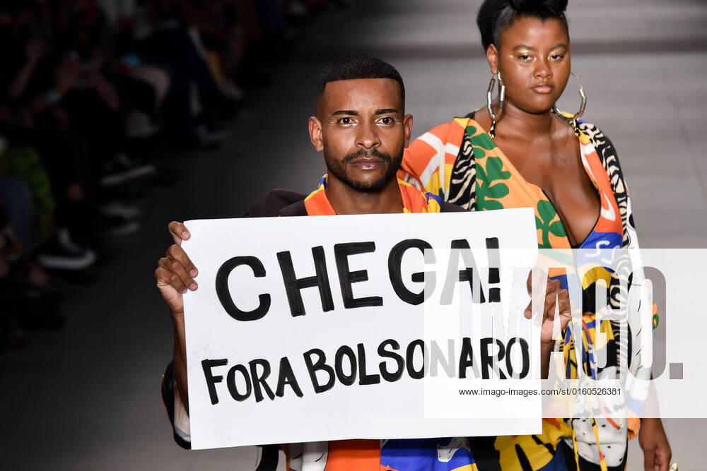 SÃO PAULO, SP - 02.06.2022: SPFW N53 - Parade of the brand, Meninos Reis, during the SPFW N53 (São Paulo Fashion Week), this Thursday, (2) at Senac Lapa Faustolo, SP. In the photo model safe poster against President Jair Bolsonaro. x2215032x RobertoxCasimiro