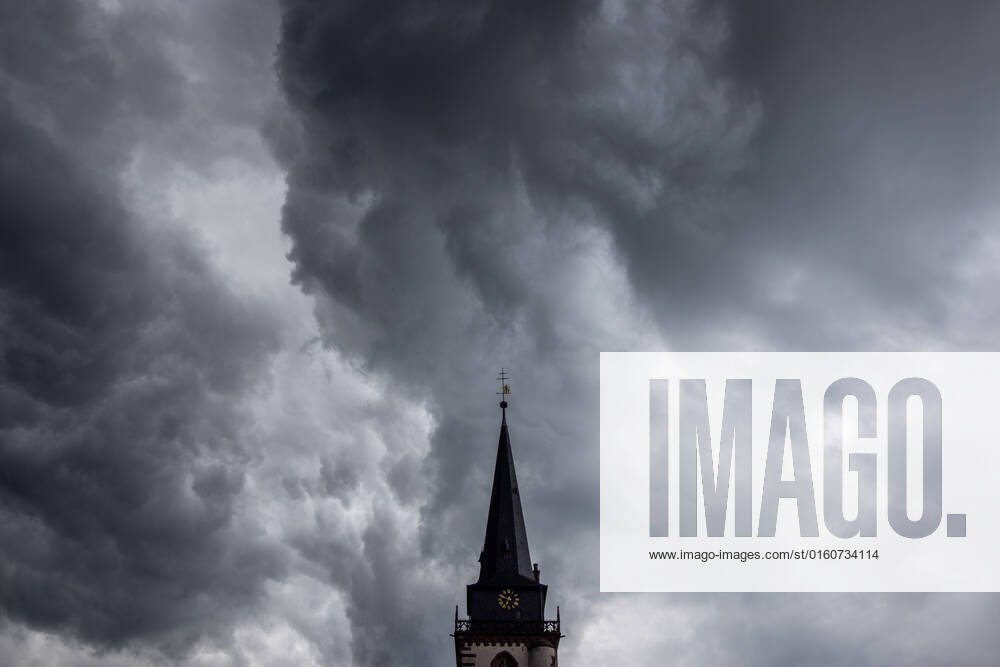 Dunkle Wolken über dem Kirchturm Dunkle Wolken eines Schauers sind am Abend am Himmel über dem Kirchturm der katholischen Kirche St.-Ursula in Oberursel zu sehen., Oberursel Hessen Deutschland