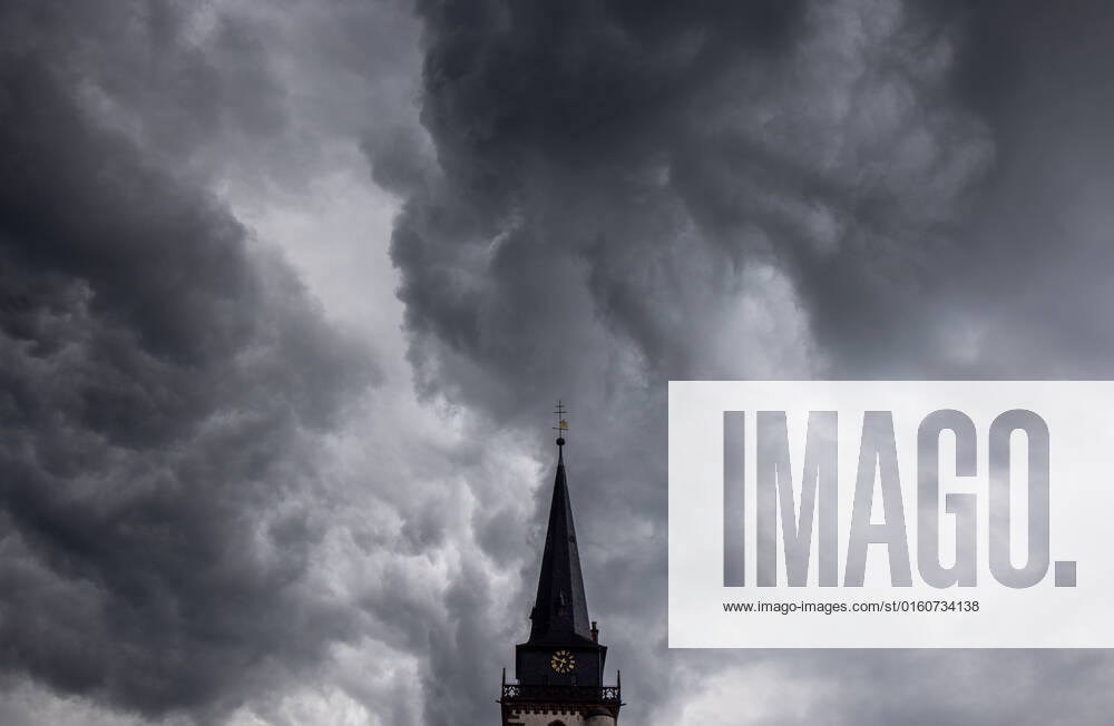 Dunkle Wolken über dem Kirchturm Dunkle Wolken eines Schauers sind am Abend am Himmel über dem Kirchturm der katholischen Kirche St.-Ursula in Oberursel zu sehen., Oberursel Hessen Deutschland