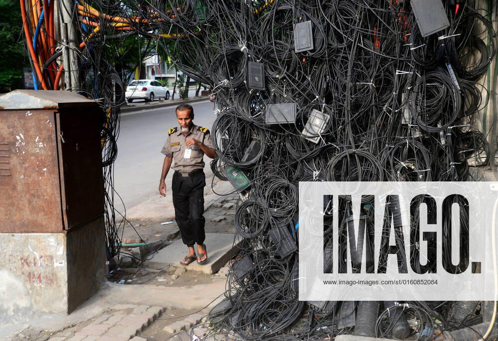 Daily Life In Dhaka People walk through the scattered internet and satellite connection cables hanging on footpath in Dhaka, Bangladesh, on June 10, 2022. Dhaka Bangladesh