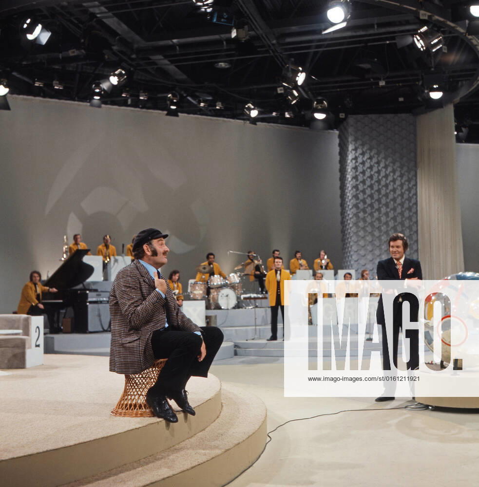 DREI MAL NEUN Drei mal Neun, ZDF Quizshow, Deutschland, 1971, im Bild: Showgast Jürgen von Manger, im Hintergrund Max Greger mit Bigband und Showmaster Wim Thoelke. Drei mal Neun, TV quiz show, Germany, 1971, on the photo: show guest, German comedian and cabaret artist Juergen von Manger, background: Max Greger with Big band and presenter Wim Thoelke., Deutschland