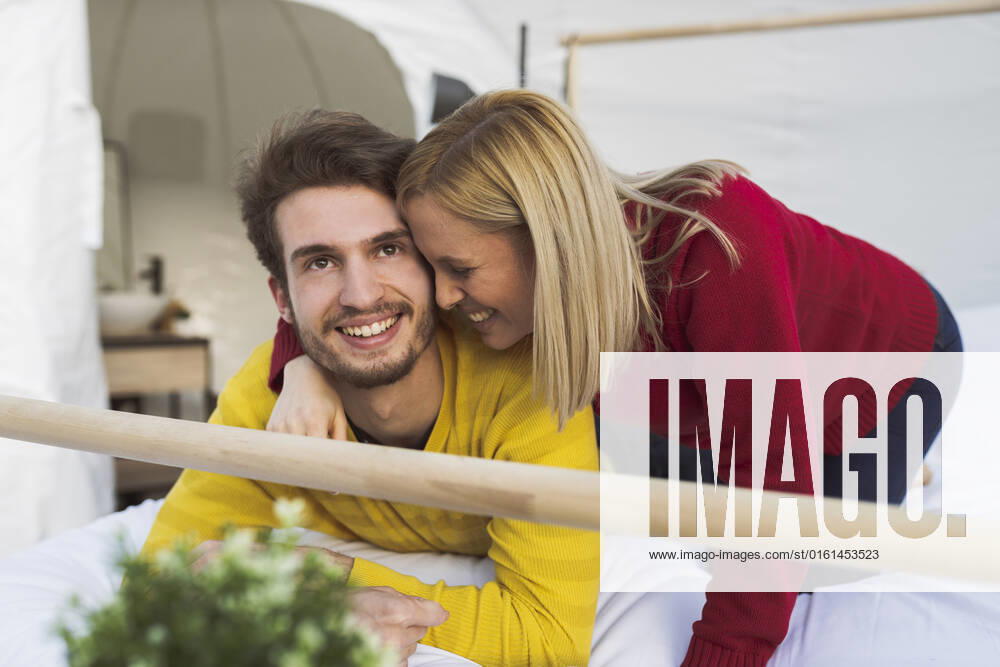 Happy woman with boyfriend lying on bed in hotel room model released, Symbolfoto property released, JCCMF06352