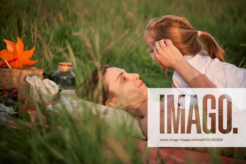 Mother talking with daughter lying on grass model released, Symbolfoto, ZEDF04620