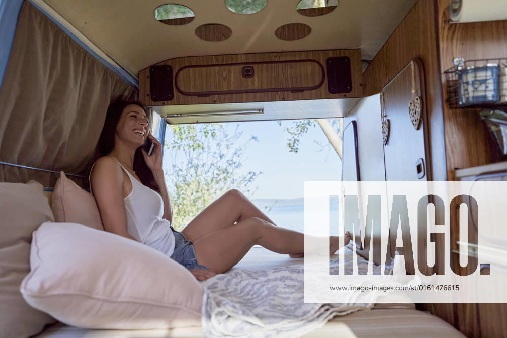 Woman laughing on smart phone in motor home model released, Symbolfoto, FMOF01467