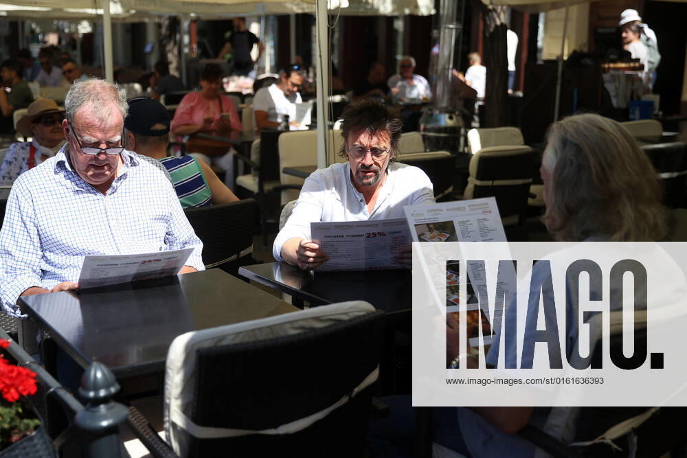 The Grand Tour stars, Jeremy Clarkson, Richard Hammond and James May, sit at a coffee shop on the Main Square in Cracow, Poland, while on tour filming the show. The Grand Tour is a British motoring television series, created by Jeremy Clarkson, Richard Hammond, James May, and Andy Wilman, made for Amazon exclusively for its online streaming service Amazon Prime Video which premiered in 2016. The programme was conceived in the wake of the departure of Clarkson, Hammond, May and Wilman from the BBC series Top Gear. Krakow Poland - ZUMAs197 20220624_zaa_s197_602