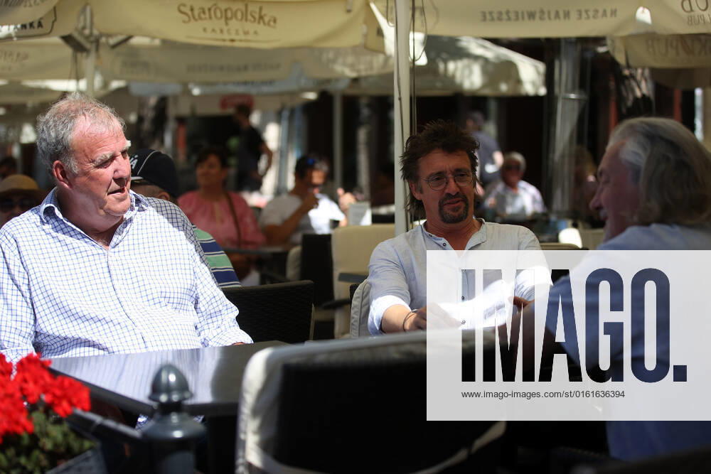 The Grand Tour stars, Jeremy Clarkson, Richard Hammond and James May, sit at a coffee shop on the Main Square in Cracow, Poland, while on tour filming the show. The Grand Tour is a British motoring television series, created by Jeremy Clarkson, Richard Hammond, James May, and Andy Wilman, made for Amazon exclusively for its online streaming service Amazon Prime Video which premiered in 2016. The programme was conceived in the wake of the departure of Clarkson, Hammond, May and Wilman from the BBC series Top Gear. Krakow Poland - ZUMAs197 20220624_zaa_s197_603