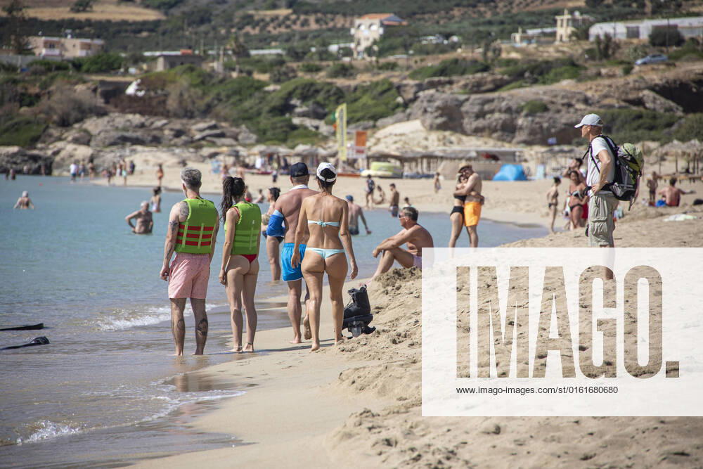 Tourism In Greece - Falassarna Beach In Crete Island Tourism in Greece - The exotic beach of Falassarna at the western side of Crete island. Falasarna bay with 5 beaches with whitish sand and crystal clear transparent tropical turquoise water hosts some of the most famous beaches in Greece, which has been awarded as the best beach of Crete and voted as one of the 10 best beaches in Europe several times in the past. Local people and tourists are seen relaxing, sunbathing, tanning, swimming, doing water sports and walking. Tourism is bouncing back with reservations exceeding the pre-pandemic numbers, putting Greece and the Greek islands on high demand. Tourists travel after the Covid-19 Coronavirus pandemic. Falassarna, Chania, Crete island,