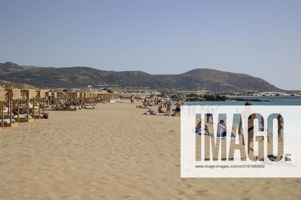 Tourism In Greece - Falassarna Beach In Crete Island Tourism in Greece - The exotic beach of Falassarna at the western side of Crete island. Falasarna bay with 5 beaches with whitish sand and crystal clear transparent tropical turquoise water hosts some of the most famous beaches in Greece, which has been awarded as the best beach of Crete and voted as one of the 10 best beaches in Europe several times in the past. Local people and tourists are seen relaxing, sunbathing, tanning, swimming, doing water sports and walking. Tourism is bouncing back with reservations exceeding the pre-pandemic numbers, putting Greece and the Greek islands on high demand. Tourists travel after the Covid-19 Coronavirus pandemic. Falassarna, Chania, Crete island,