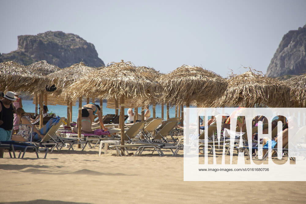 Tourism In Greece - Falassarna Beach In Crete Island Tourism in Greece - The exotic beach of Falassarna at the western side of Crete island. Falasarna bay with 5 beaches with whitish sand and crystal clear transparent tropical turquoise water hosts some of the most famous beaches in Greece, which has been awarded as the best beach of Crete and voted as one of the 10 best beaches in Europe several times in the past. Local people and tourists are seen relaxing, sunbathing, tanning, swimming, doing water sports and walking. Tourism is bouncing back with reservations exceeding the pre-pandemic numbers, putting Greece and the Greek islands on high demand. Tourists travel after the Covid-19 Coronavirus pandemic. Falassarna, Chania, Crete island,