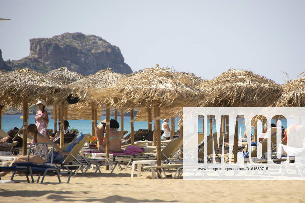 Tourism In Greece - Falassarna Beach In Crete Island Tourism in Greece - The exotic beach of Falassarna at the western side of Crete island. Falasarna bay with 5 beaches with whitish sand and crystal clear transparent tropical turquoise water hosts some of the most famous beaches in Greece, which has been awarded as the best beach of Crete and voted as one of the 10 best beaches in Europe several times in the past. Local people and tourists are seen relaxing, sunbathing, tanning, swimming, doing water sports and walking. Tourism is bouncing back with reservations exceeding the pre-pandemic numbers, putting Greece and the Greek islands on high demand. Tourists travel after the Covid-19 Coronavirus pandemic. Falassarna, Chania, Crete island,