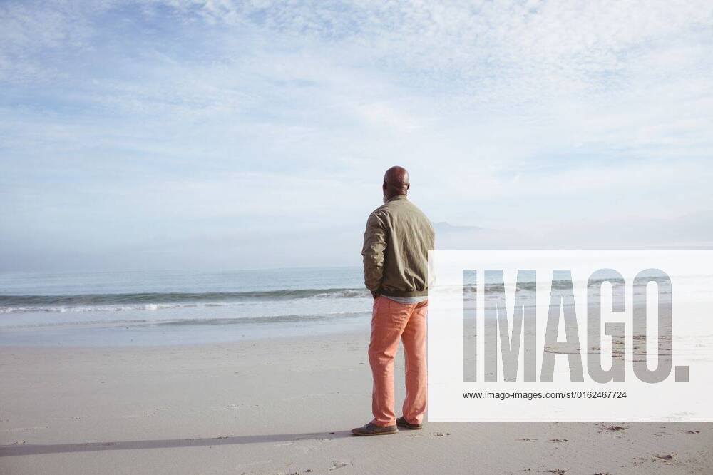 African-American man standing on the beach Rear view of handsome senior African-American man looking at the sea while standing on the beach on a beautiful day. Authentic Senior Retired Life Concept, model released, , property released, Cape Town, South Africa, 19.03.2019, 1262724.jpg, senior life, active seniors, retirement, lifestyle, leisure, coastline, shore, ocean, sea, beach, waves, water, sunny, sand bright, vacation, summertime, holidays, calm, peaceful, relaxing, content, blue, sky, sunlight, clear, sunshine, sun, clouds, cloud, skies, cloudy, outdoor, day, nature, weather, bright, light Mature Adult,Man,Male,Black Outdoors,Rear view,Day
