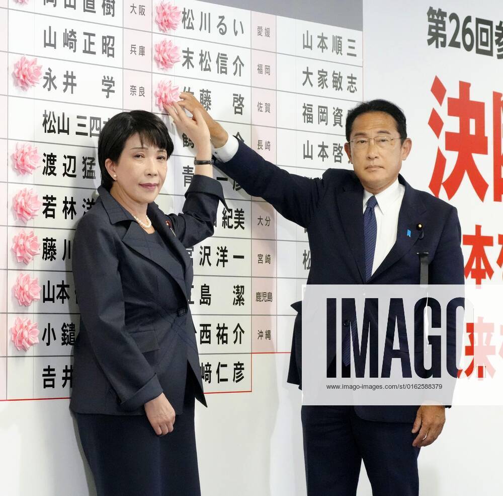 Japan upper house election Japanese Prime Minister Fumio Kishida (R) and Liberal Democratic Party policy chief Sanae Takaichi attach a rosette to the name of an LDP candidate assured of victory in the House of Councillors election on July 10, 2022, at the party s election operations center in Tokyo. A14AA0001313004P