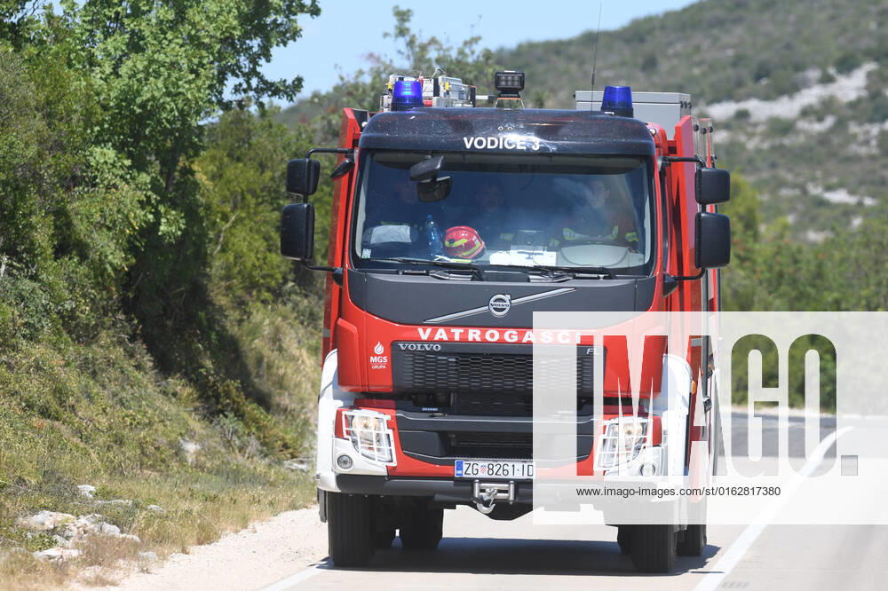 PXL_A fire near Vodice, Croatia Fire in an open area near the Velika Mrdakovica archaeological site in the Vodice hinterland, Croatia on July 13, 2022. About 30 firefighters with a dozen vehicles are on the ground, and two Canadairs joined the ground forces in extinguishing the fire. There are pine forests above, low vegetation, and endangered buildings. HrvojexJelavic PIXSELL