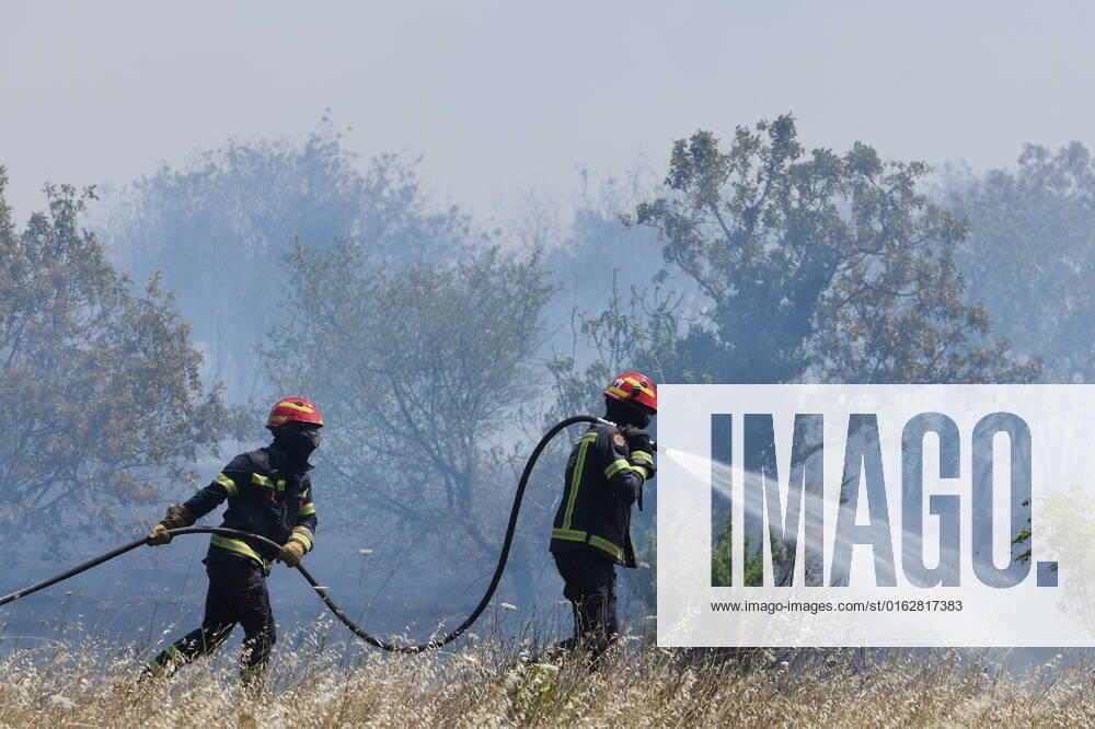 PXL_A fire near Vodice, Croatia Fire in an open area near the Velika Mrdakovica archaeological site in the Vodice hinterland, Croatia on July 13, 2022. About 30 firefighters with a dozen vehicles are on the ground, and two Canadairs joined the ground forces in extinguishing the fire. There are pine forests above, low vegetation, and endangered buildings. HrvojexJelavic PIXSELL