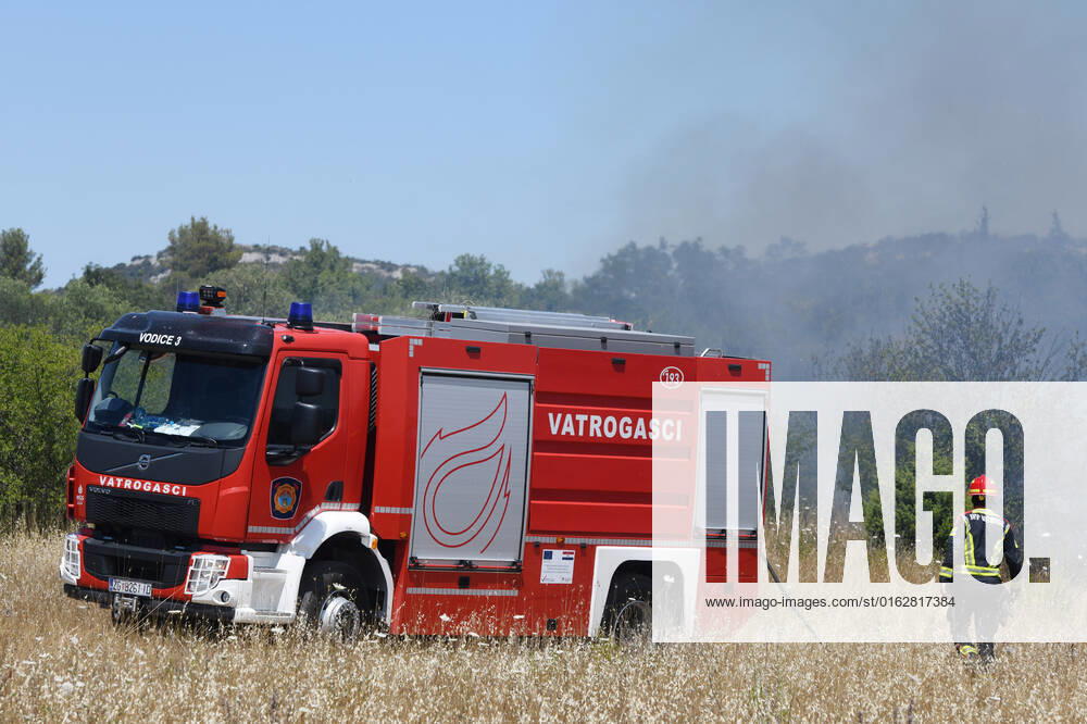 PXL_A fire near Vodice, Croatia Fire in an open area near the Velika Mrdakovica archaeological site in the Vodice hinterland, Croatia on July 13, 2022. About 30 firefighters with a dozen vehicles are on the ground, and two Canadairs joined the ground forces in extinguishing the fire. There are pine forests above, low vegetation, and endangered buildings. HrvojexJelavic PIXSELL