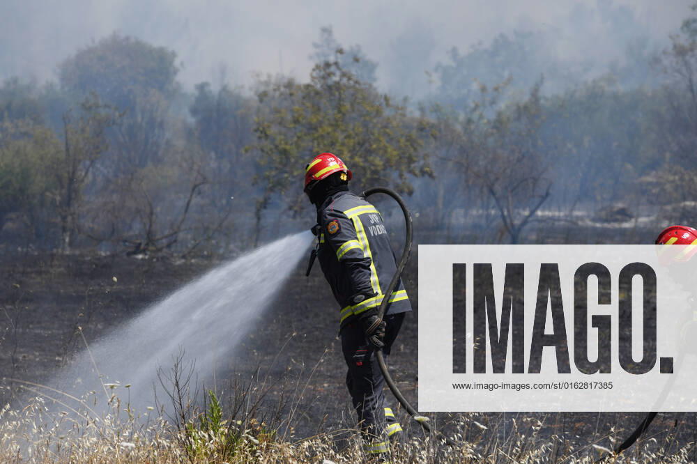 PXL_A fire near Vodice, Croatia Fire in an open area near the Velika Mrdakovica archaeological site in the Vodice hinterland, Croatia on July 13, 2022. About 30 firefighters with a dozen vehicles are on the ground, and two Canadairs joined the ground forces in extinguishing the fire. There are pine forests above, low vegetation, and endangered buildings. HrvojexJelavic PIXSELL