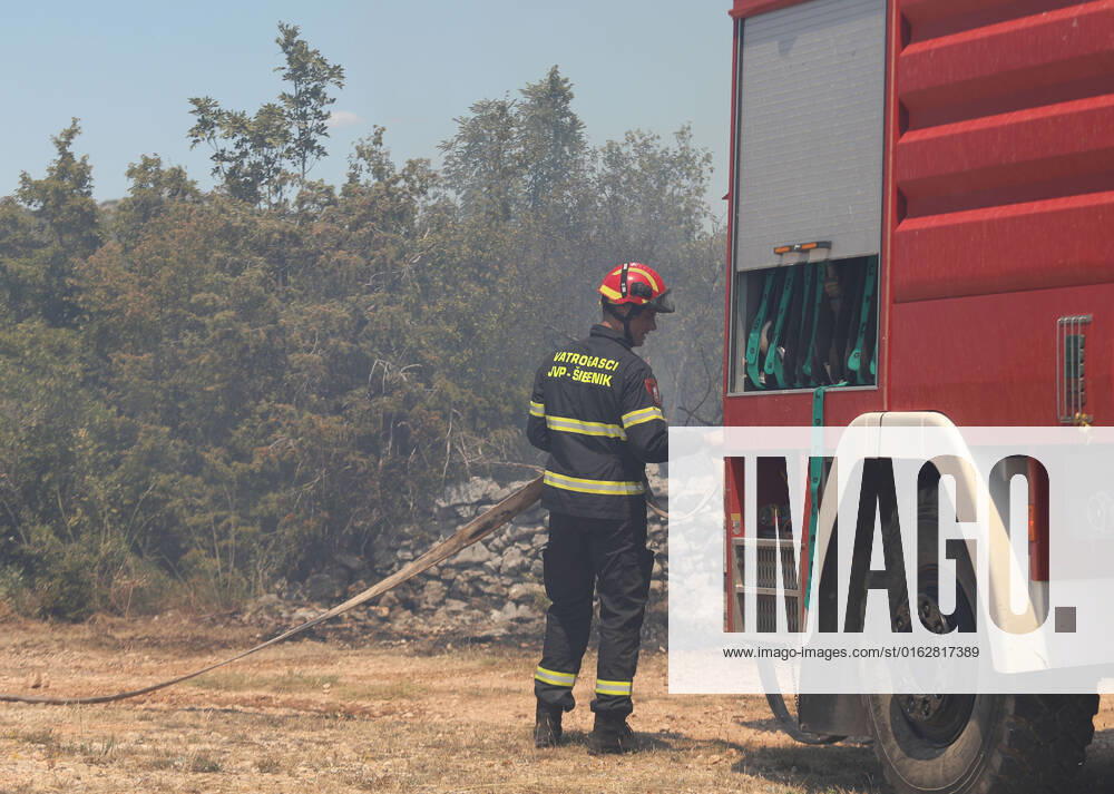 PXL_A fire near Vodice, Croatia Fire in an open area near the Velika Mrdakovica archaeological site in the Vodice hinterland, Croatia on July 13, 2022. About 30 firefighters with a dozen vehicles are on the ground, and two Canadairs joined the ground forces in extinguishing the fire. There are pine forests above, low vegetation, and endangered buildings. DuskoxJaramaz PIXSELL