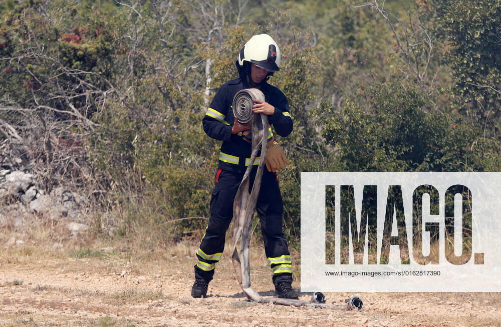 PXL_A fire near Vodice, Croatia Fire in an open area near the Velika Mrdakovica archaeological site in the Vodice hinterland, Croatia on July 13, 2022. About 30 firefighters with a dozen vehicles are on the ground, and two Canadairs joined the ground forces in extinguishing the fire. There are pine forests above, low vegetation, and endangered buildings. DuskoxJaramaz PIXSELL