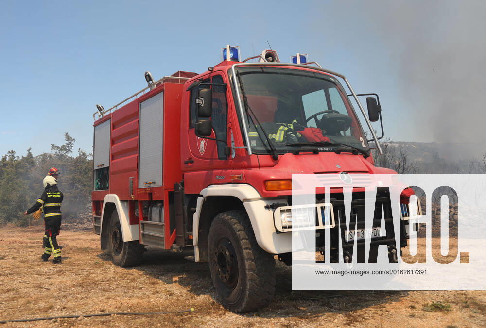 PXL_A fire near Vodice, Croatia Fire in an open area near the Velika Mrdakovica archaeological site in the Vodice hinterland, Croatia on July 13, 2022. About 30 firefighters with a dozen vehicles are on the ground, and two Canadairs joined the ground forces in extinguishing the fire. There are pine forests above, low vegetation, and endangered buildings. DuskoxJaramaz PIXSELL