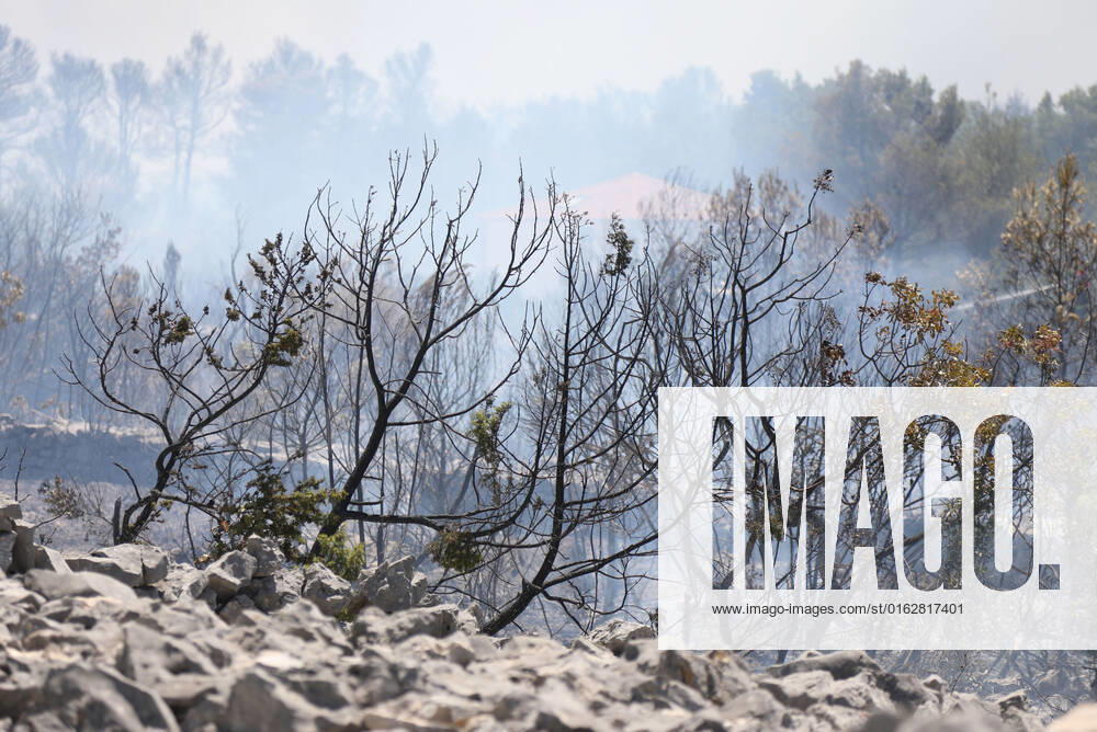 PXL_A fire near Vodice, Croatia Fire in an open area near the Velika Mrdakovica archaeological site in the Vodice hinterland, Croatia on July 13, 2022. About 30 firefighters with a dozen vehicles are on the ground, and two Canadairs joined the ground forces in extinguishing the fire. There are pine forests above, low vegetation, and endangered buildings. DuskoxJaramaz PIXSELL