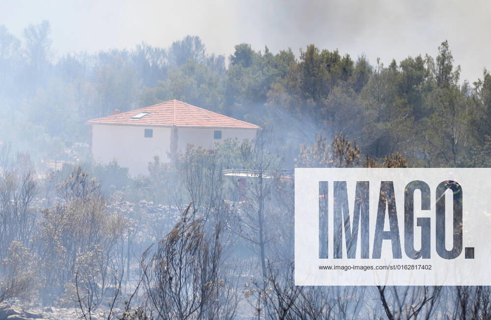PXL_A fire near Vodice, Croatia Fire in an open area near the Velika Mrdakovica archaeological site in the Vodice hinterland, Croatia on July 13, 2022. About 30 firefighters with a dozen vehicles are on the ground, and two Canadairs joined the ground forces in extinguishing the fire. There are pine forests above, low vegetation, and endangered buildings. DuskoxJaramaz PIXSELL