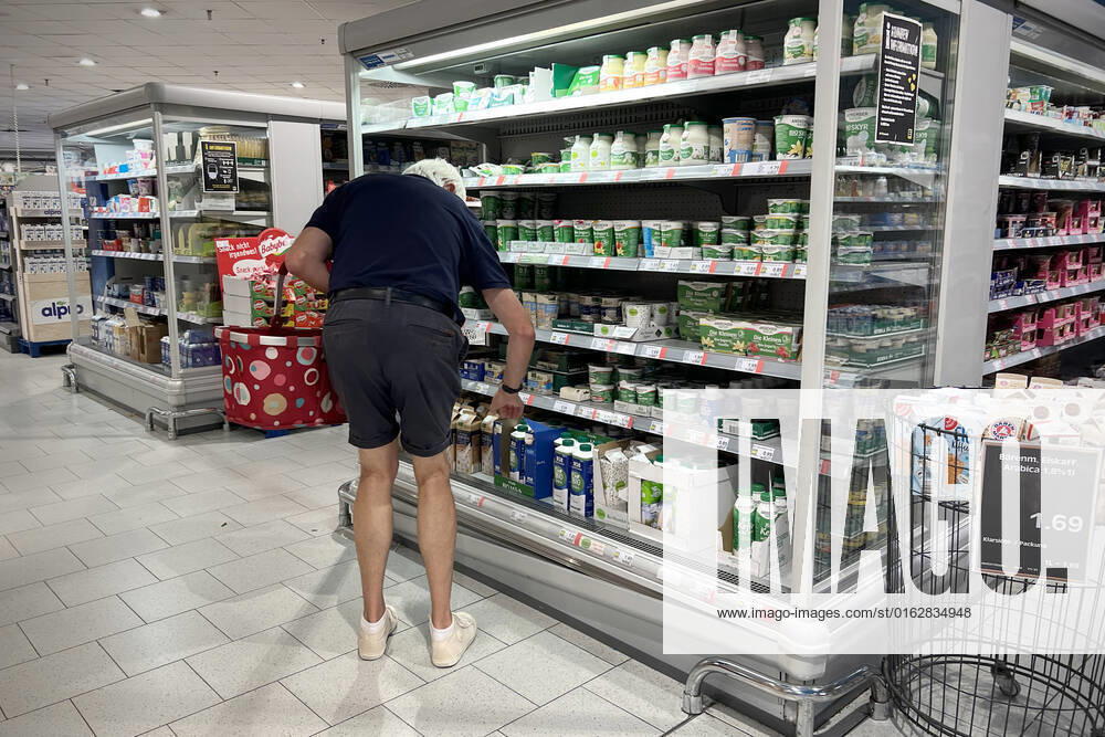 VERBRAUCHERPREISE: Inflation in Deutschland Ein Mann,Kunde steht vor einem Kuehlregal und blickt gebannt auf die Preise, Preisschild,Preisaushang,Kuehltheke, Milchprodukte, Einkauf,Inflation,Verbraucherpreise,Teuerung,