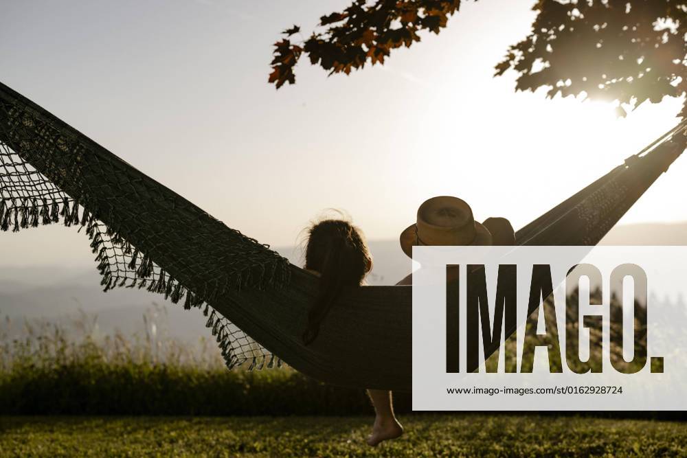 IMAGO Creative: Ende des Sommers Paar liegt in einer Hängematte bei Sonnenuntergang, Kärnten, Österreich, Europa