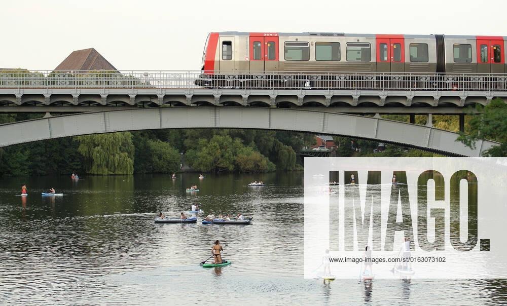 Passanten paddeln auf Stand-up Paddle Boards auf einem Alsterkanal unter einer Brücke entlang, die gerade von einer U-Bahn überquert wird. Am Dienstagabend herrschten in Hamburg bis in die späten Abendstunden noch Temperaturen bis an die 30 Grad. Hohenfelde Hamburg