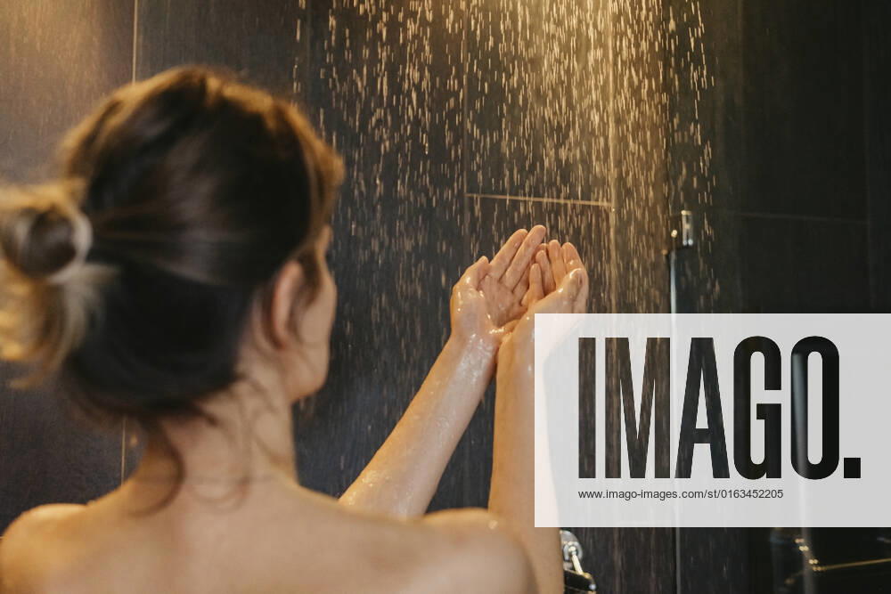 Woman examining water temperature in shower model released, Symbolfoto property released, SEAF01016