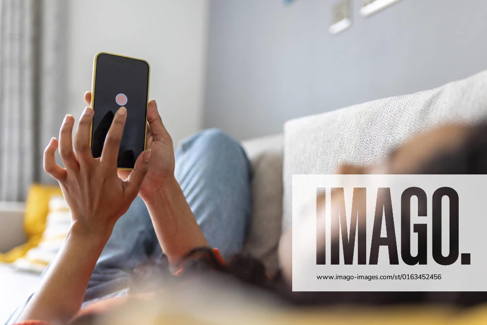 IMAGO Creative, Lifestyle, Tik Tok-Trend thatgirl IMAGO Creative: Business, Innovative Technologie-Lösungen Woman turning off mobile phone using smart phone in living room model released, Symbolfoto property released, WPEF06007