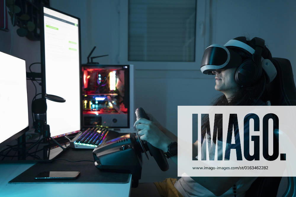 IMAGO Creative, Lifestyle, Gaming Man wearing VR glasses using steering wheel sitting at home model released, Symbolfoto property released, DAMF00999