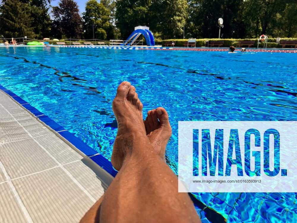 Schwimmen im Freibad Bad Wörishofen (Bayern), ein Mann sitzt am Schwimmbecken am Wasser. (Model Release vorhanden) 26.07.2022, Relaxen im Freibad 26.07.2022, Relaxen im Freibad