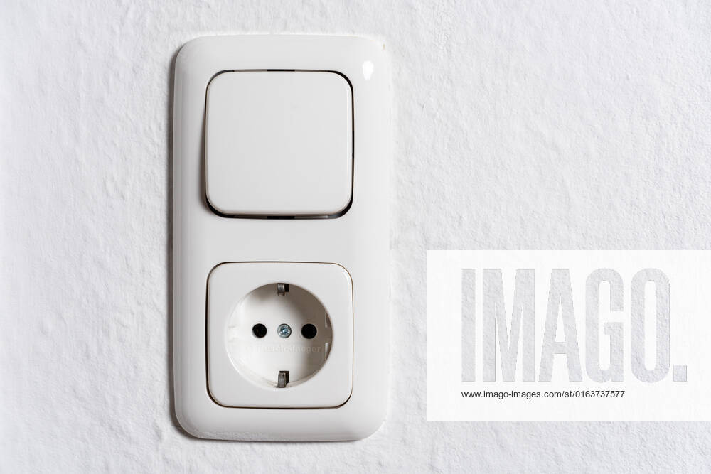 Lichtschalter und Steckdose an der Wand eines Zimmers