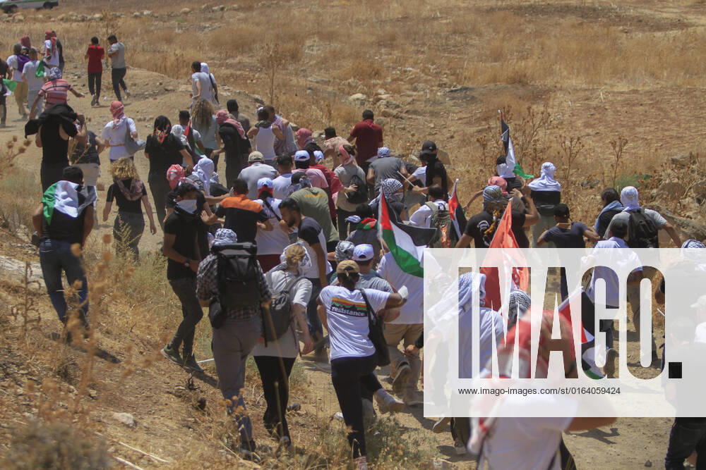 Nablus, West bank, Palestine: Protesters from Palestinian and foreign peace movements rush to hide from Israeli soldiers during the demonstration against Israeli settlements in the village of Beit Dajan near the West Bank city of Nablus. Nablus Palestine - ZUMAs197 20220802_zaa_s197_050