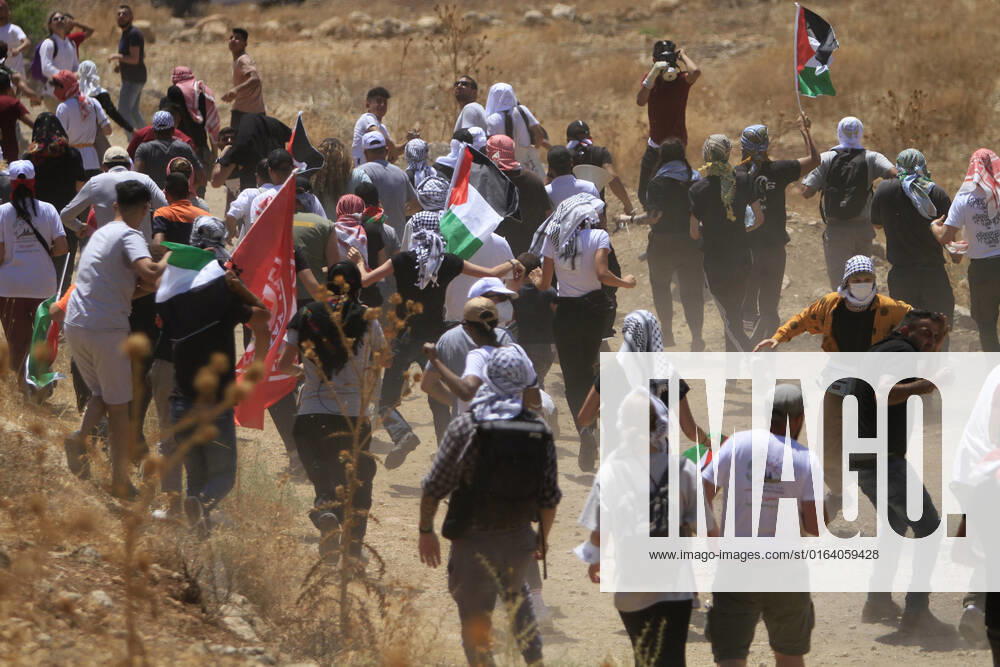 Nablus, West bank, Palestine: Protesters from Palestinian and foreign peace movements rush to hide from Israeli soldiers during the demonstration against Israeli settlements in the village of Beit Dajan near the West Bank city of Nablus. Nablus Palestine - ZUMAs197 20220802_zaa_s197_052