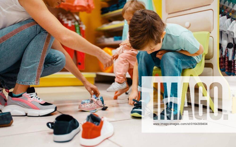 Mother with children choosing shoes in kids store, Mother with her little children choosing shoes in kids store. Happy mom with daughter and son buying clothes in supermarket together, family shopping, Mother with her little children choosing shoes in kids store. Happy mom with daughter and son buying clothes in supermarket together, family shopping model released, Symbolfoto , 05.02.2020,