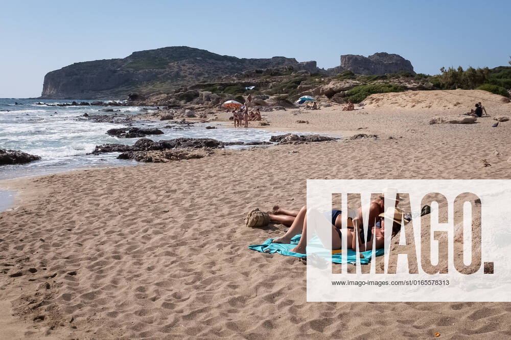 Tourism In Greece - Falassarna Beach In Crete Island People are enjoy their time at Falassarna beach near Chania, Crete Island, Greece on August 14, 2022. Falassarna is located 59 kilometers west of Chania. Today is one of the most famous destinations in Crete, for its beaches and for reasons of ecological interest. Falassarna Greece