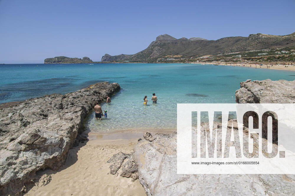 Tourism In Greece - Falassarna Beach In Crete Island Tourism in Greece - The exotic beach of Falassarna at the western side of Crete island during a high-temperature day, heatwave. Falasarna bay with 5 beaches made of whitish sand and crystal clear transparent tropical turquoise water hosts some of the most famous beaches in Greece, which has been awarded multiple times as the best beach of Crete and voted as one of the 10 best beaches in Europe several times in the past. Local people and tourists are seen relaxing, sunbathing, tanning, swimming, doing water sports and walking. Tourism is bouncing back with reservations overpassing the pre-pandemic numbers, putting Greece and the Greek islands on high demand. Tourists travel after the Covid