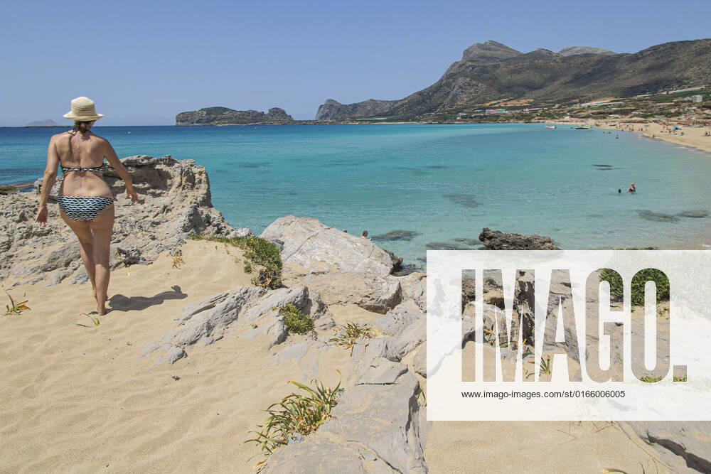 Tourism In Greece - Falassarna Beach In Crete Island Tourism in Greece - The exotic beach of Falassarna at the western side of Crete island during a high-temperature day, heatwave. Falasarna bay with 5 beaches made of whitish sand and crystal clear transparent tropical turquoise water hosts some of the most famous beaches in Greece, which has been awarded multiple times as the best beach of Crete and voted as one of the 10 best beaches in Europe several times in the past. Local people and tourists are seen relaxing, sunbathing, tanning, swimming, doing water sports and walking. Tourism is bouncing back with reservations overpassing the pre-pandemic numbers, putting Greece and the Greek islands on high demand. Tourists travel after the Covid