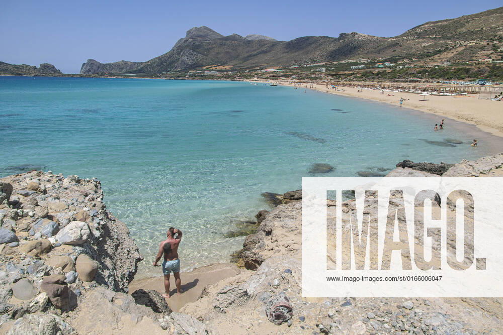 Tourism In Greece - Falassarna Beach In Crete Island Tourism in Greece - The exotic beach of Falassarna at the western side of Crete island during a high-temperature day, heatwave. Falasarna bay with 5 beaches made of whitish sand and crystal clear transparent tropical turquoise water hosts some of the most famous beaches in Greece, which has been awarded multiple times as the best beach of Crete and voted as one of the 10 best beaches in Europe several times in the past. Local people and tourists are seen relaxing, sunbathing, tanning, swimming, doing water sports and walking. Tourism is bouncing back with reservations overpassing the pre-pandemic numbers, putting Greece and the Greek islands on high demand. Tourists travel after the Covid