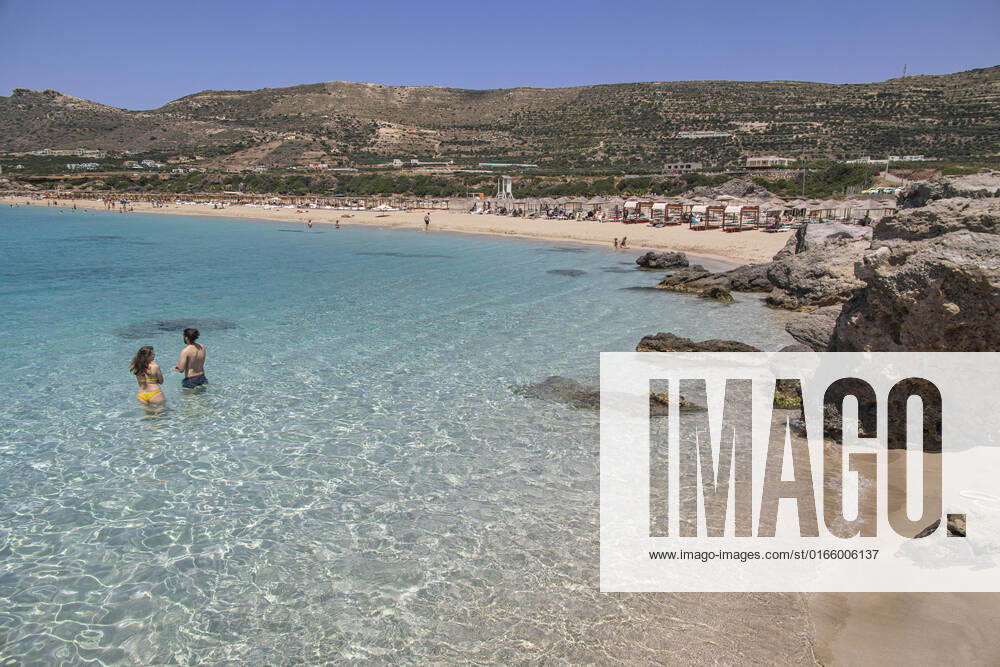 Tourism In Greece - Falassarna Beach In Crete Island Tourism in Greece - The exotic beach of Falassarna at the western side of Crete island during a high-temperature day, heatwave. Falasarna bay with 5 beaches made of whitish sand and crystal clear transparent tropical turquoise water hosts some of the most famous beaches in Greece, which has been awarded multiple times as the best beach of Crete and voted as one of the 10 best beaches in Europe several times in the past. Local people and tourists are seen relaxing, sunbathing, tanning, swimming, doing water sports and walking. Tourism is bouncing back with reservations overpassing the pre-pandemic numbers, putting Greece and the Greek islands on high demand. Tourists travel after the Covid