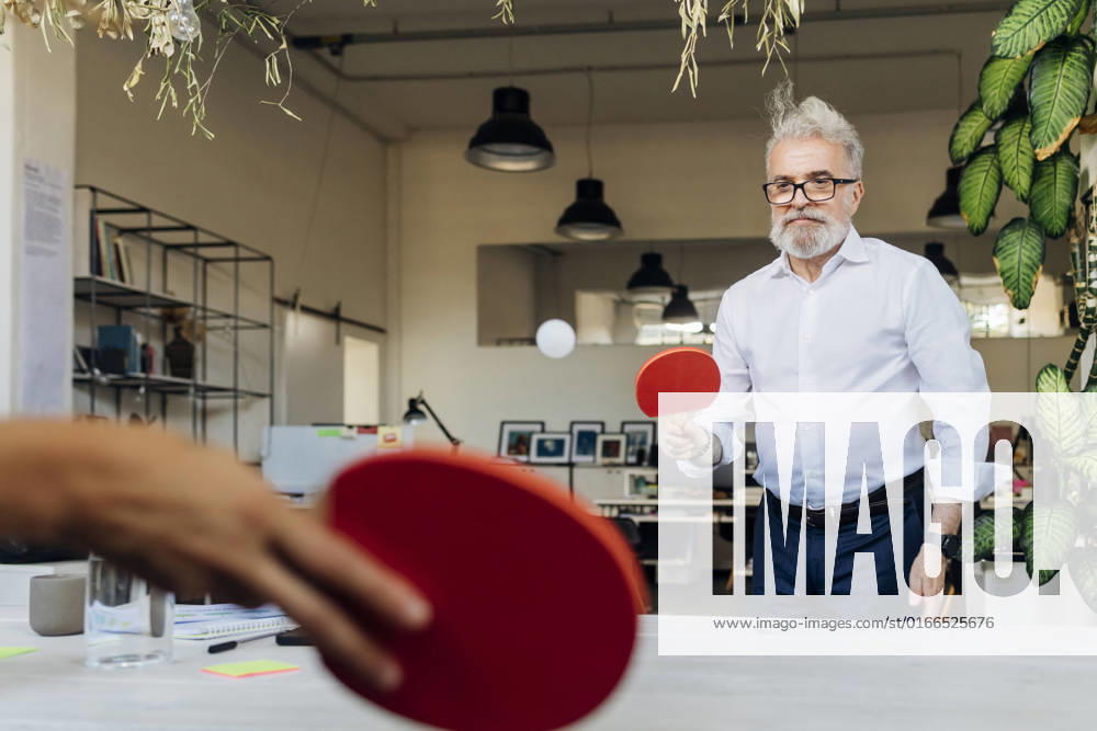 IMAGO Creative: Business - Work-Life Balance Businessman playing table tennis with coworker at office model released, Symbolfoto property released, MEUF07154