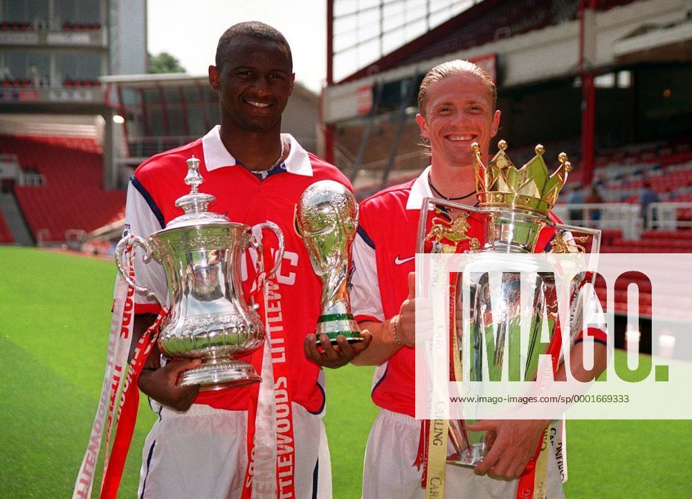 Weltmeister und englischer Doublegewinner - Patrick Vieira (li.) mit dem FA Pokal und einer Nachbildung des Weltpokals, daneben Emanuel Petit (beide Frankreich; Arsenal London) mit dem englischen Meisterpokal - Fußball Herren English Premier League 1998 1999, 1. Englische Liga, Arsenal FC London, Pokalsammler Gruppe Trophäensammlung, Trophäensammler, Pokalsammlung London Harmonie, Freude,