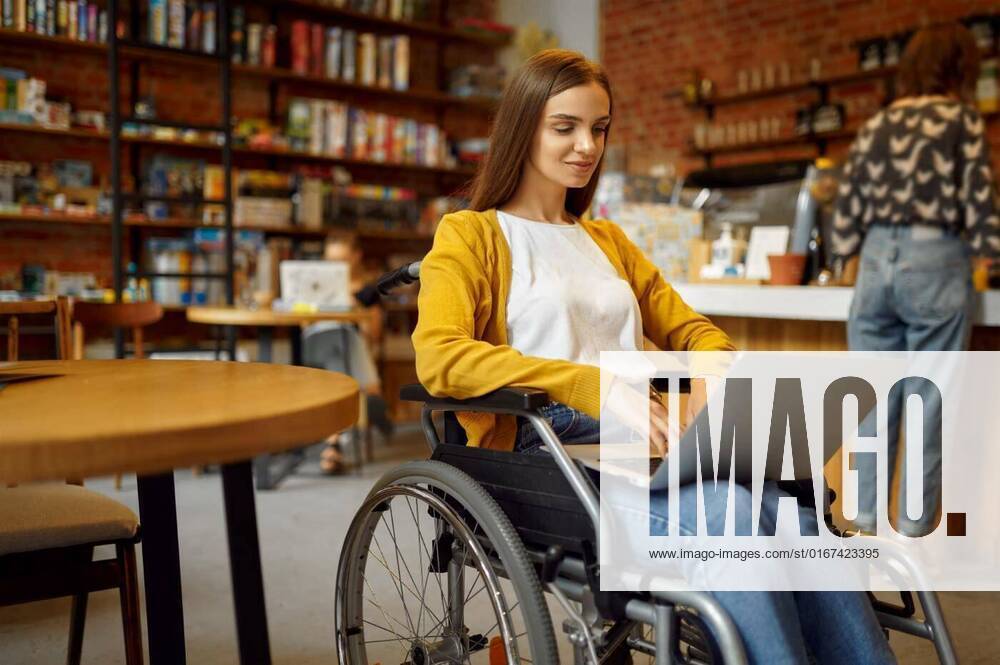 Disabled student in wheelchair works on laptop, Disabled female student in wheelchair works on laptop, disability, bookshelf and university library interior on background. Handicapped young woman studying in college, paralyzed people get knowledge, Disabled female student in wheelchair works on laptop, disability, bookshelf and university library interior on background. Handicapped young woman studying in college, paralyzed people get knowledge, 01.10.2021,