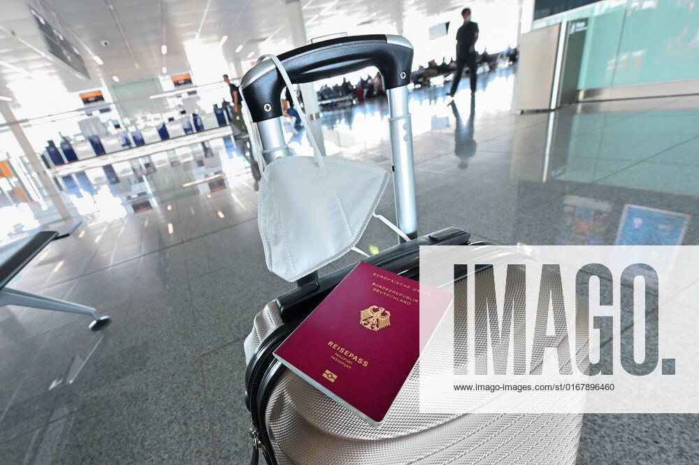 Auf dem Koffer am Flughafen, liegen Reisepass und Mundschutz griffbereit. Im Flugzeug bleibt die Maskenpflicht. München Bayern Deutschland