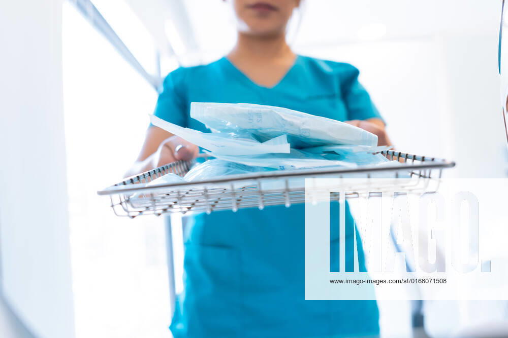 IMAGO Creative, Jahreszeit Sommer, Hitze Crop unrecognizable female doctor in uniform sterilizing dental tools before work in modern clinic, Model released EduuSandoval_ID533_20927_020